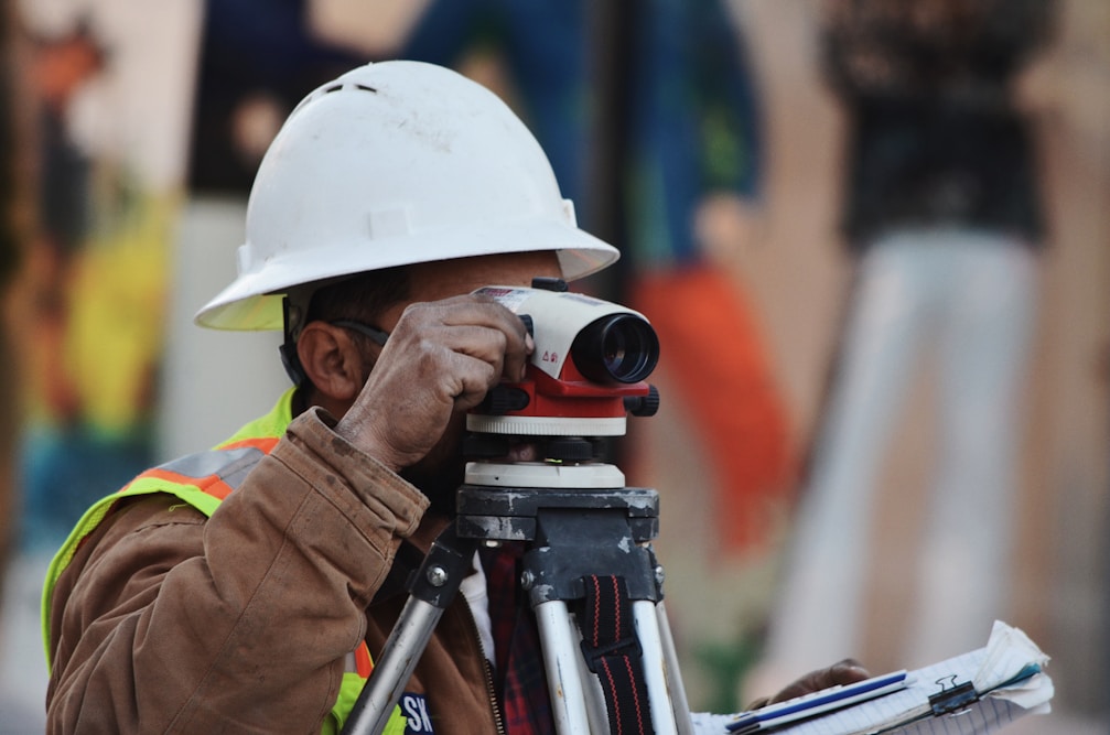 Surveyor using theodolite in the field