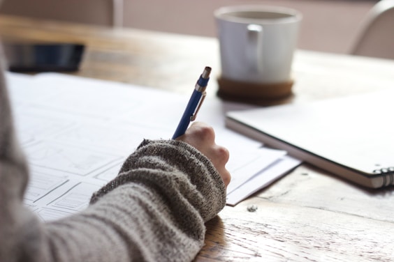 Close-up of pen writing on notebook